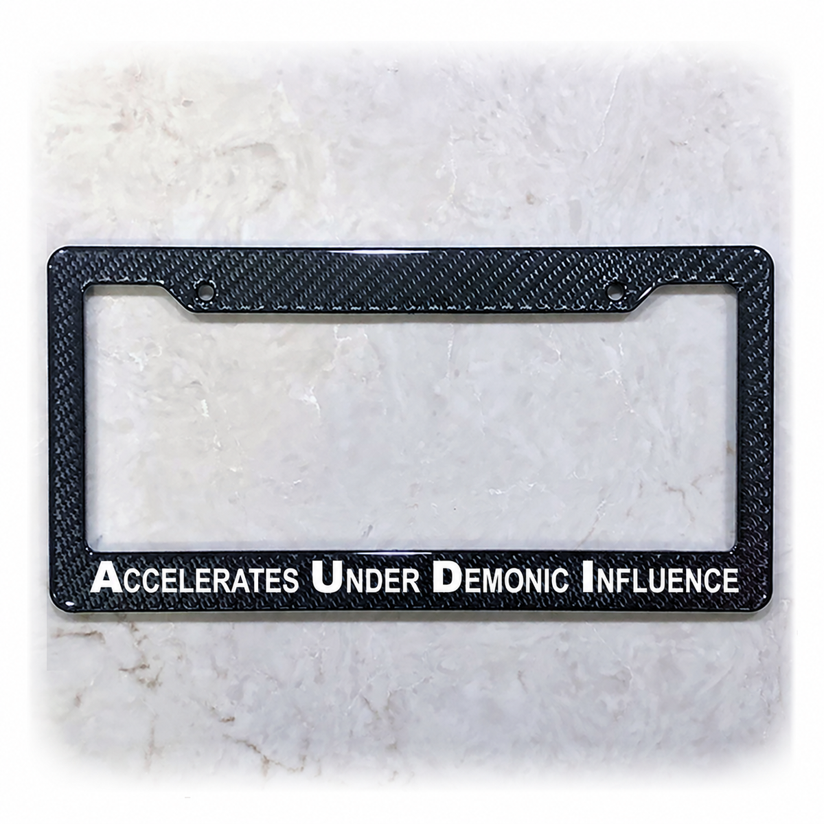 Accelerates Under Demonic Influence license plate frame in carbon fiber overlay on ABS